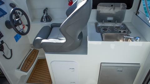 Enclosed wheelhouse starboard fridge module with twin burner cooker and sink.